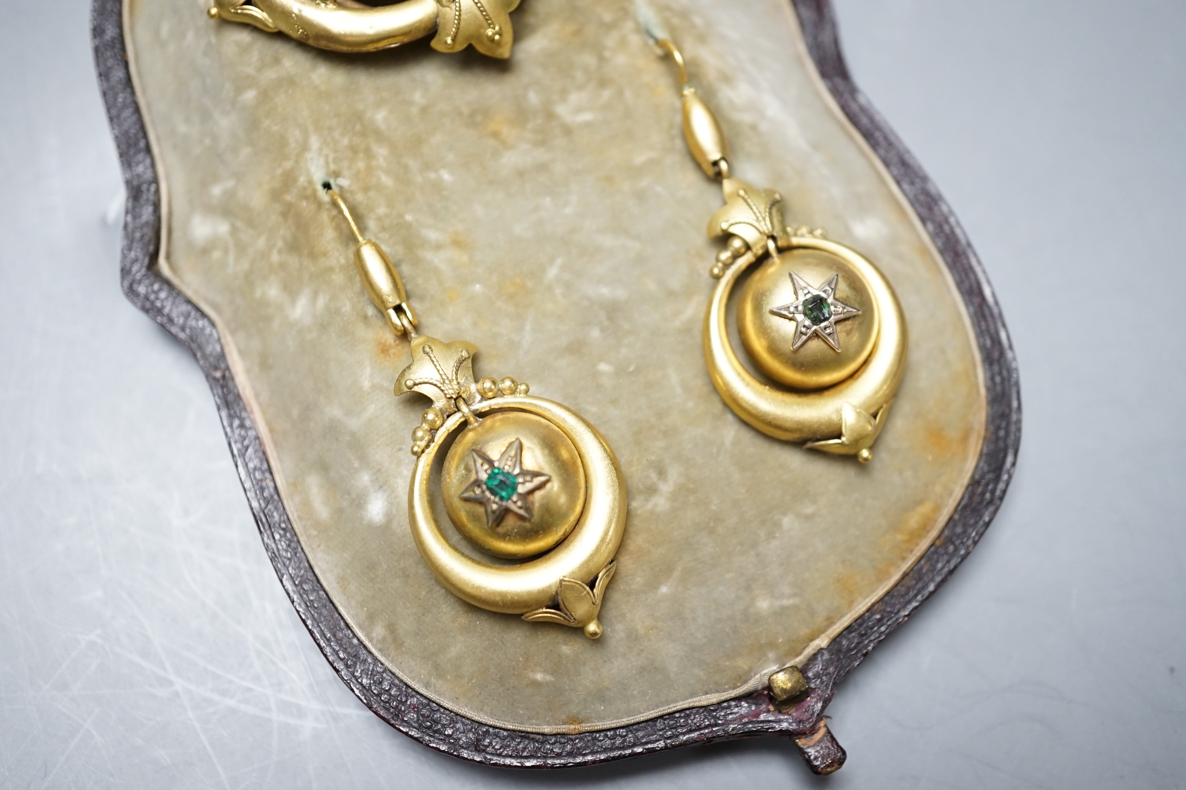 A cased Victorian yellow metal and emerald? set demi parure, comprising a brooch and pair of drop earrings, brooch width 41mm, gross weight 10.8 grams.